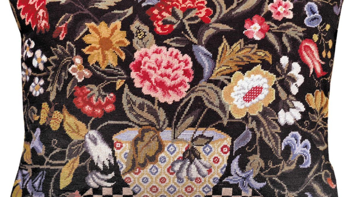 Hooked vs. needlepoint vs. embroidered pillows: a petit point needlepoint floral pillow showing the fully stitched wool surface