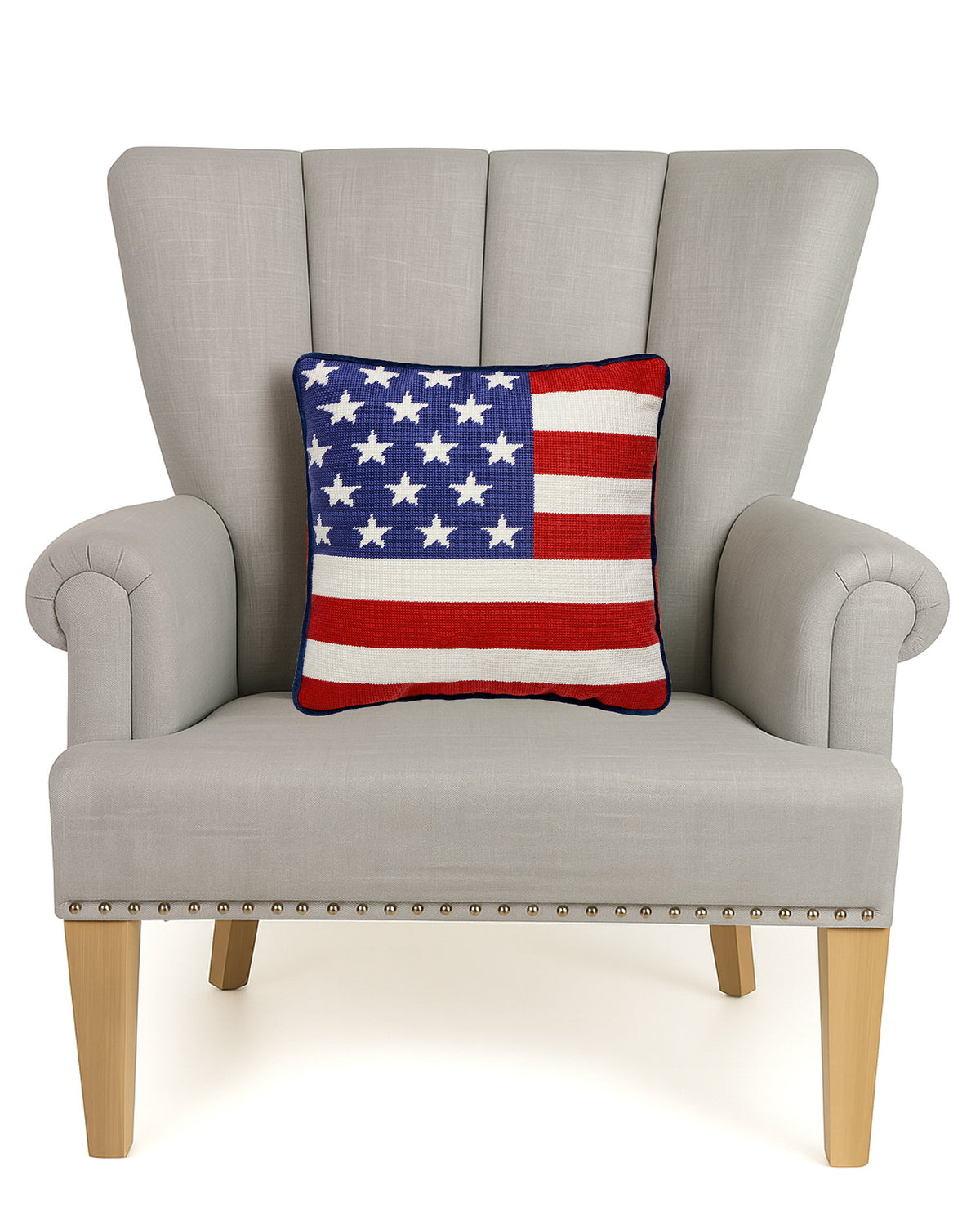 American Flag Embroidered Needlepoint Patriotic Throw Pillow on an armchair, showing the throw pillow at room scale, 14x14 inch