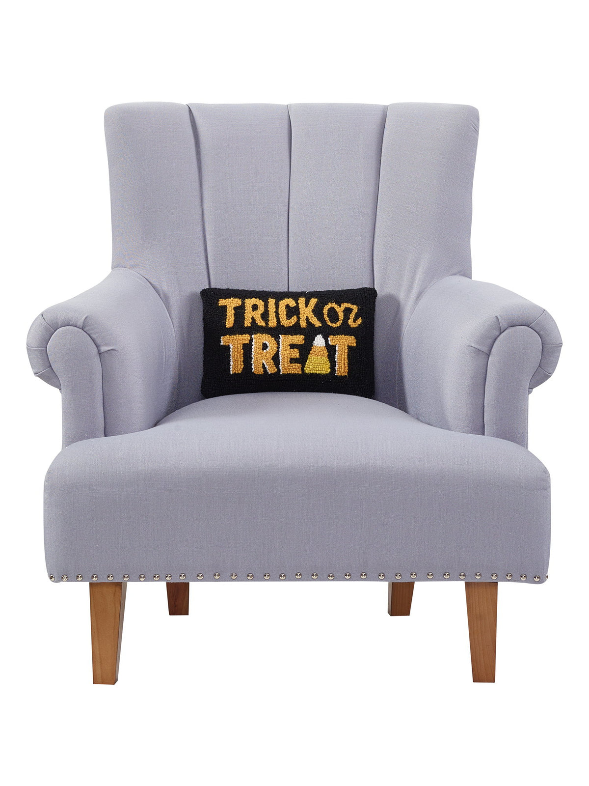 Black and Gold Trick or Treat Hooked Wool Halloween Throw Pillow on an armchair, showing the throw pillow at room scale, 8x12 inch