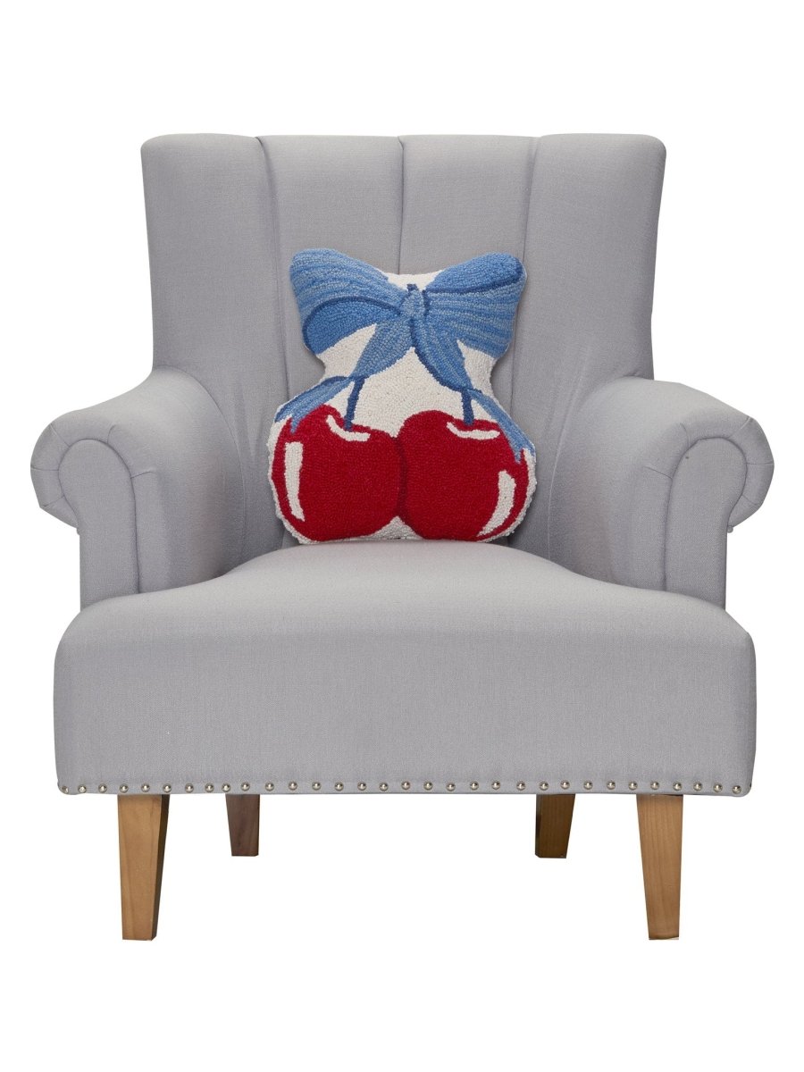 Blue Bow Shaped Cherries Hooked Wool Throw Pillow on an armchair, showing the throw pillow at room scale, 14x16 inch