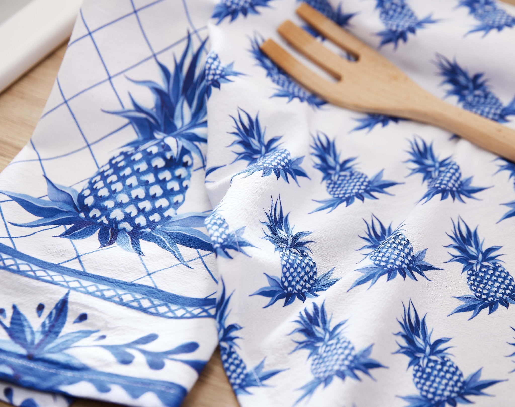 Blue Pineapple Kitchen Towel, 18x25 inch, hanging from an oven handle in a white kitchen