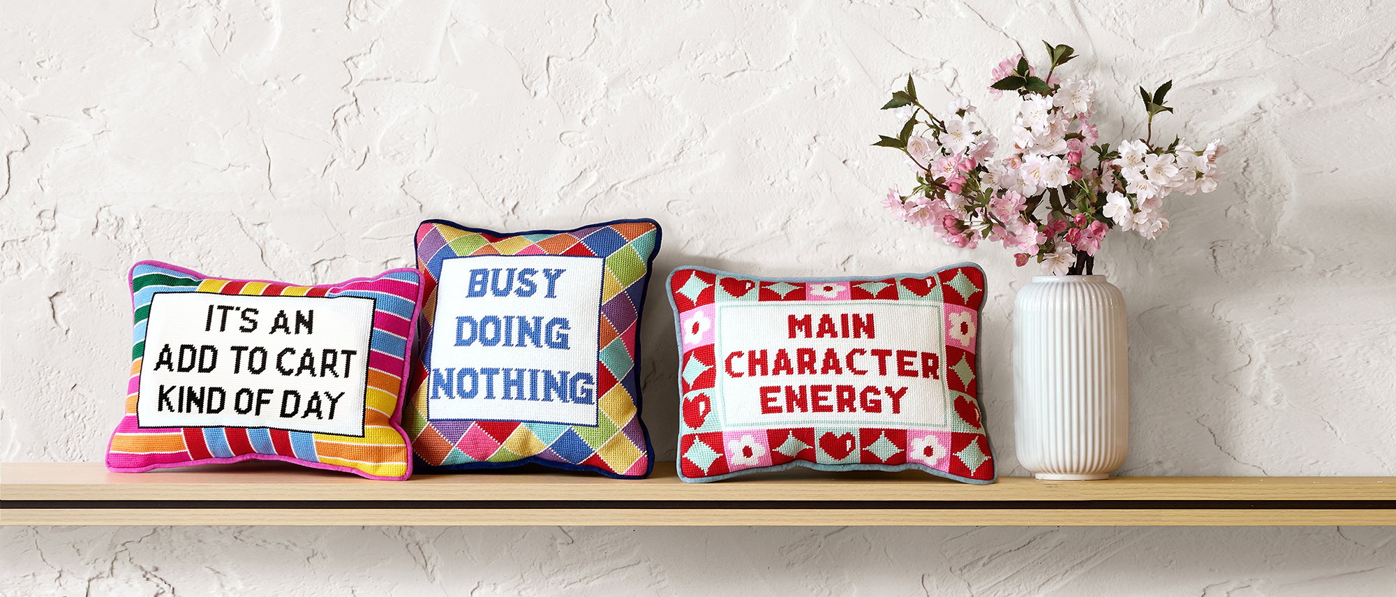 Character Energy Embroidered Needlepoint Throw Pillow shown alongside other designs in the same collection, 10x14 inch