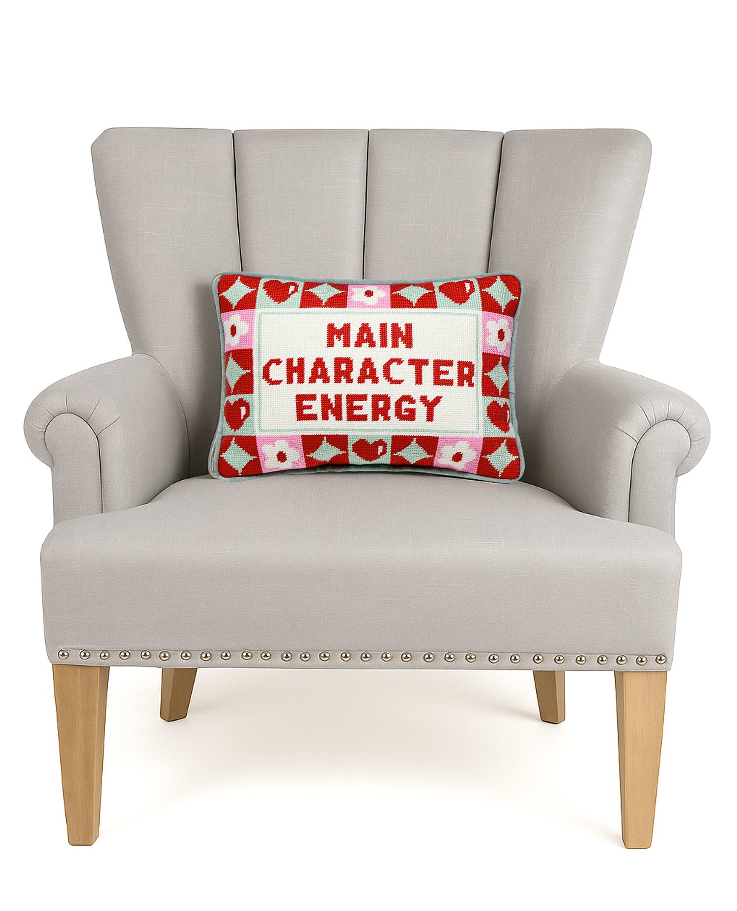 Character Energy Embroidered Needlepoint Throw Pillow on an armchair, showing the throw pillow at room scale, 10x14 inch