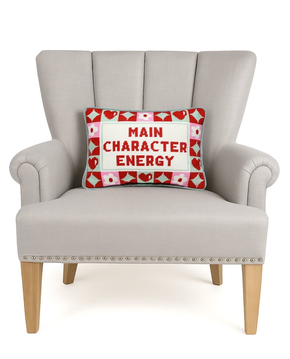 Character Energy Embroidered Needlepoint Throw Pillow on an armchair, showing the throw pillow at room scale, 10x14 inch