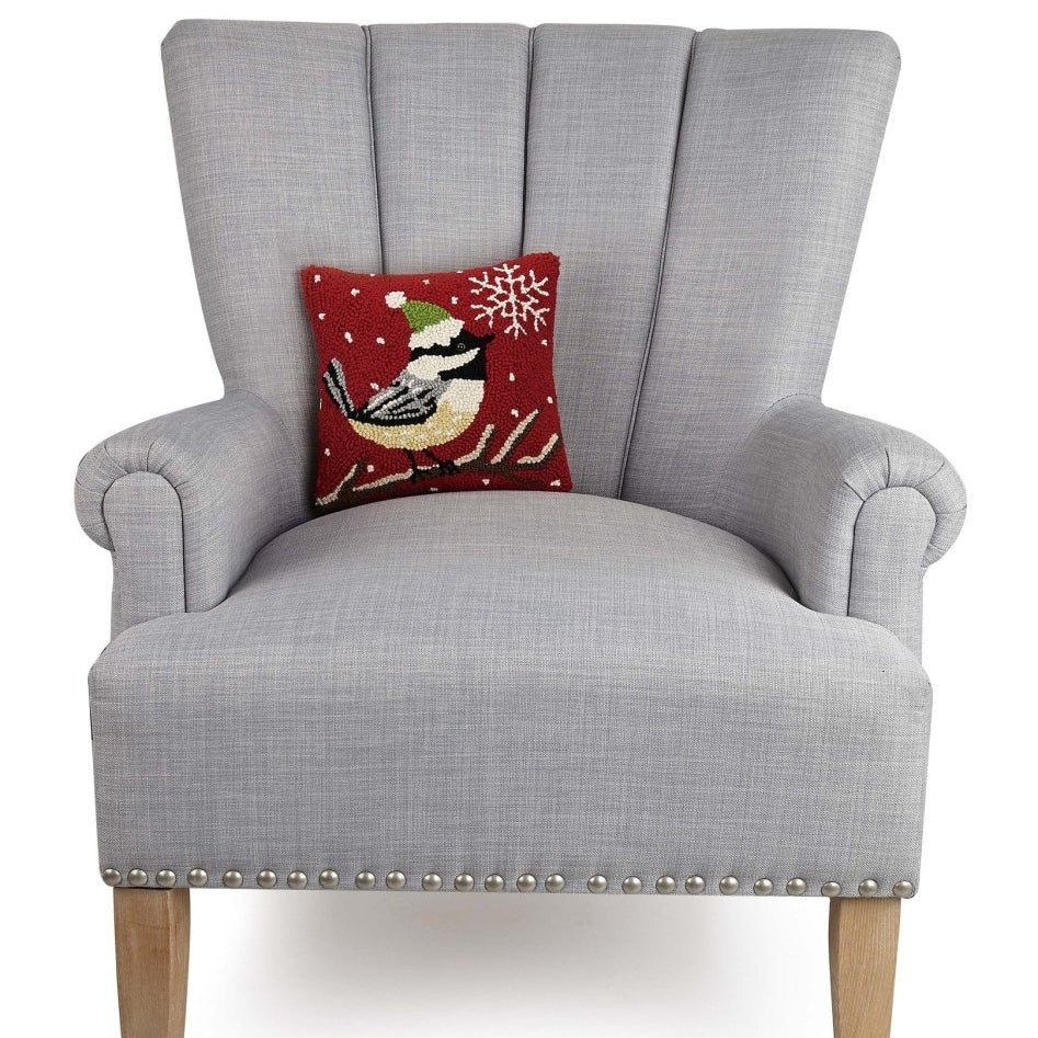 Chickadee with Snowflake Hooked Wool Christmas Throw Pillow on an armchair, showing the throw pillow at room scale, 10x10 inch