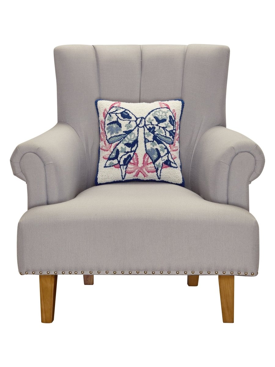 Chinoiserie Bow Hooked Wool Throw Pillow on an armchair, showing the throw pillow at room scale, 14x14 inch