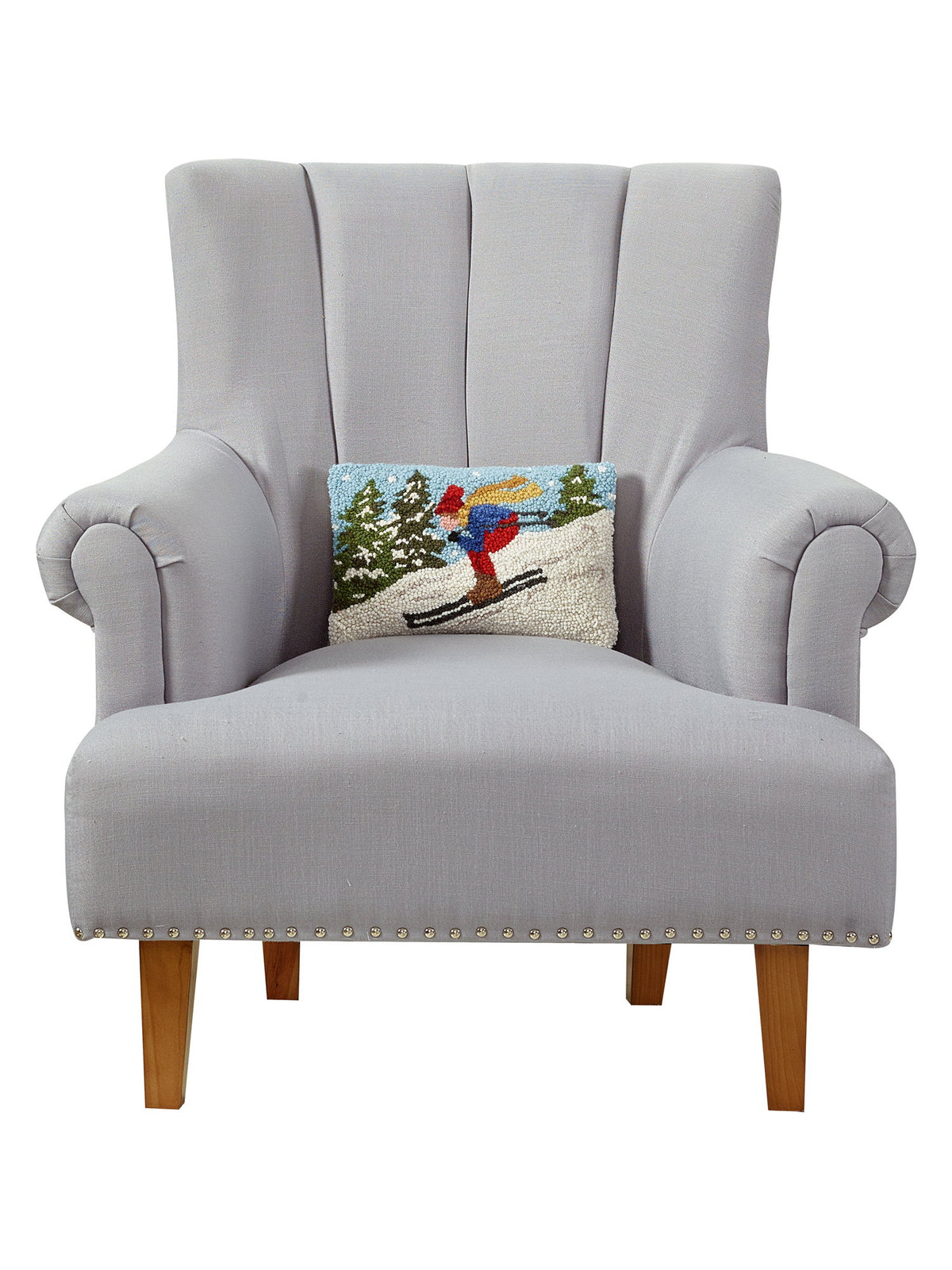 Downhill Skier Hooked Wool Christmas Throw Pillow on an armchair, showing the throw pillow at room scale, 8x12 inch