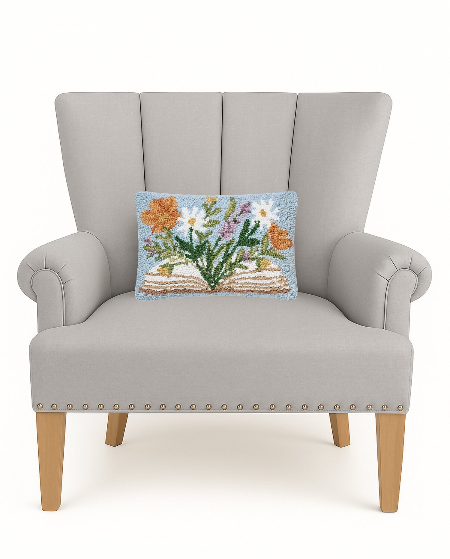 Flower Book Hooked Wool Throw Pillow on an armchair, showing the throw pillow at room scale, 8x12 inch
