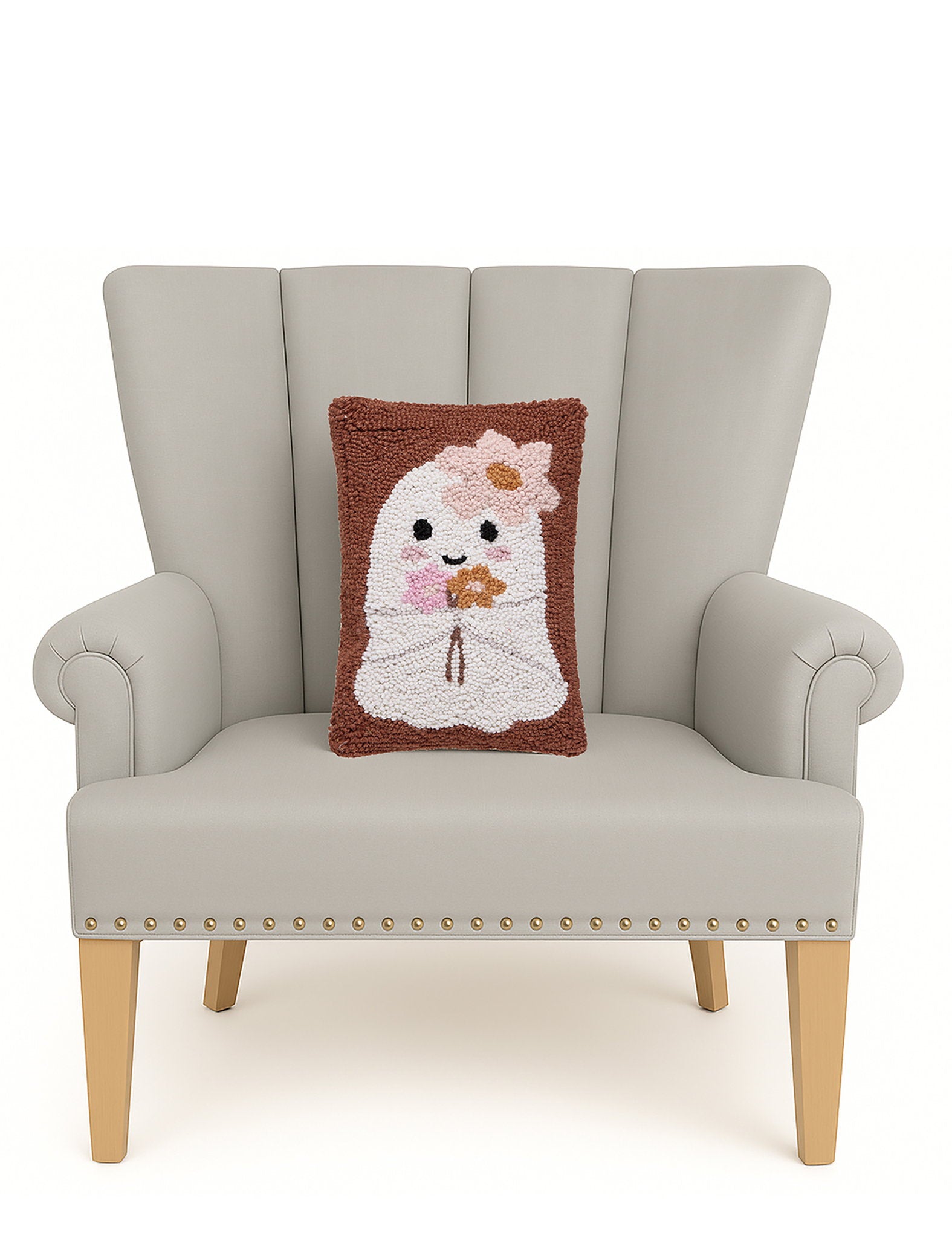 Ghost with Daisies Hooked Wool Halloween Throw Pillow on an armchair, showing the throw pillow at room scale, 8x12 inch