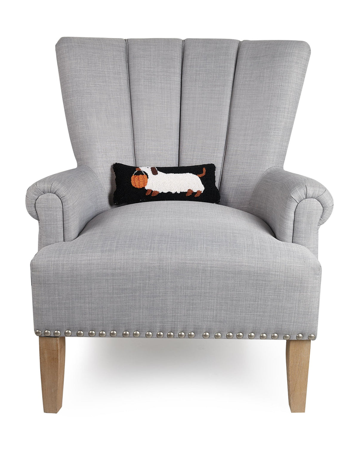 Halloween Dachshund Hooked Wool Throw Pillow on an armchair, showing the throw pillow at room scale, 12x5 inch