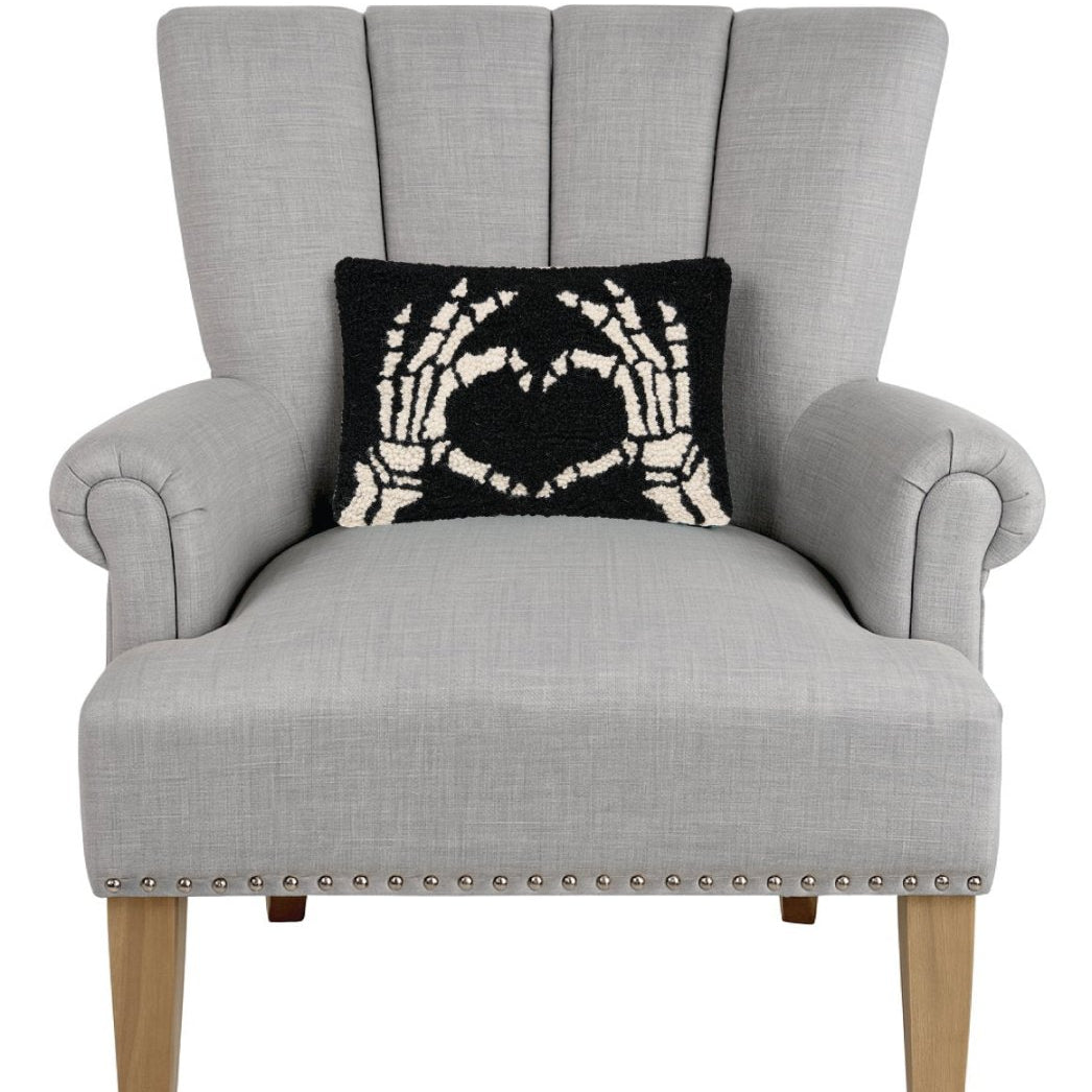 Heart Skeleton Hand Hooked Wool Halloween Throw Pillow on an armchair, showing the throw pillow at room scale, 8x12 inch