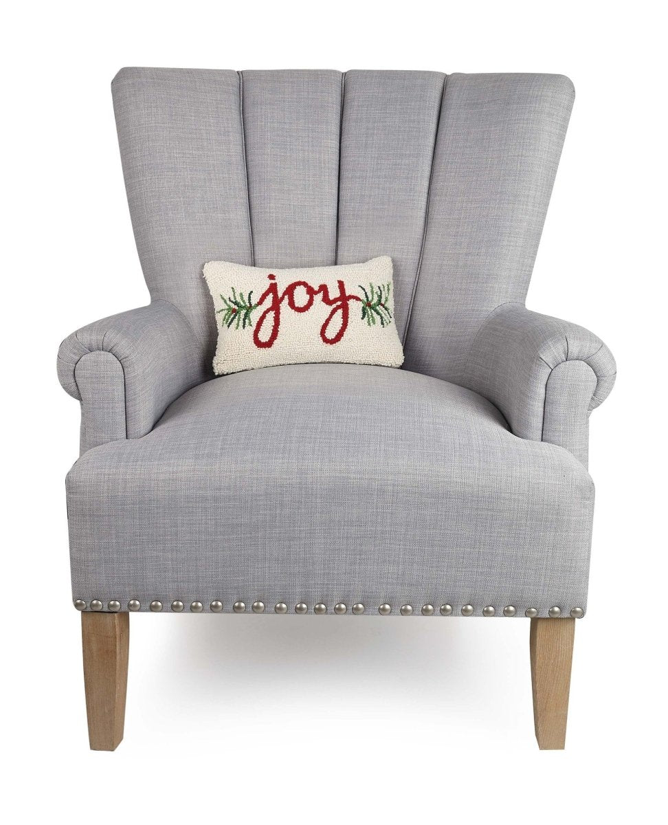 Joy Hooked Wool Christmas Throw Pillow on an armchair, showing the throw pillow at room scale, 8x12 inch