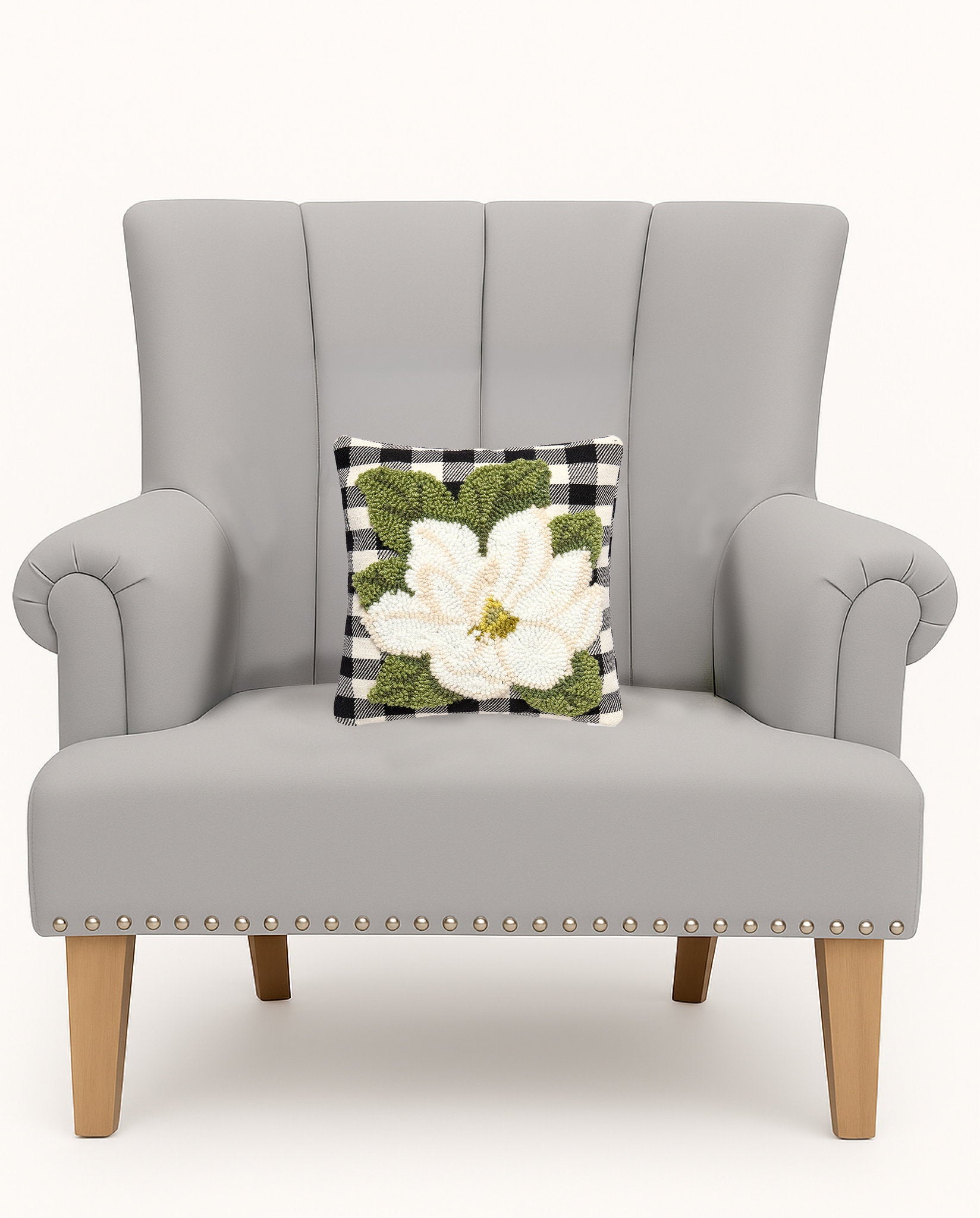 Magnolia Tufted Poly Hooked Throw Pillow on an armchair, showing the throw pillow at room scale, 10x10 inch