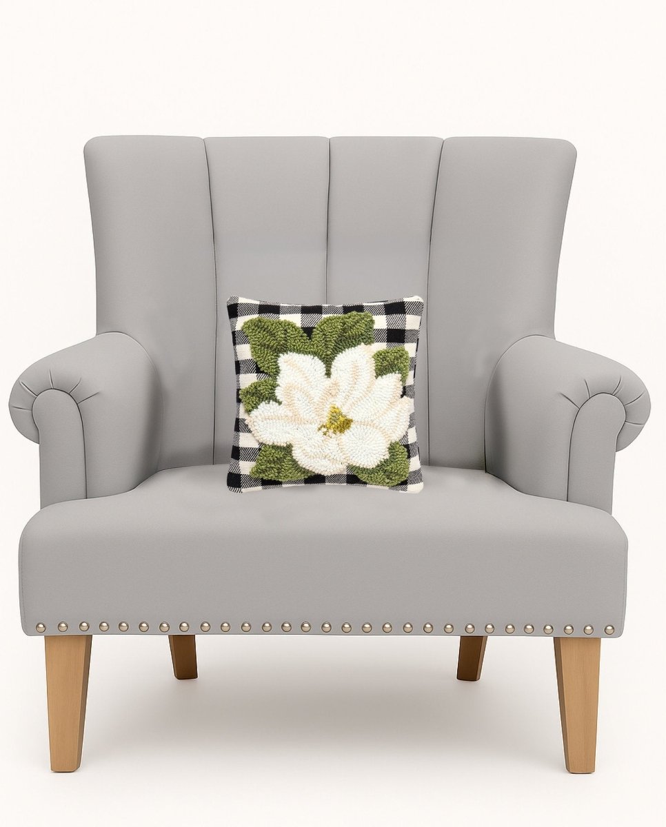 Magnolia Tufted Poly Hooked Throw Pillow on an armchair, showing the throw pillow at room scale, 10x10 inch