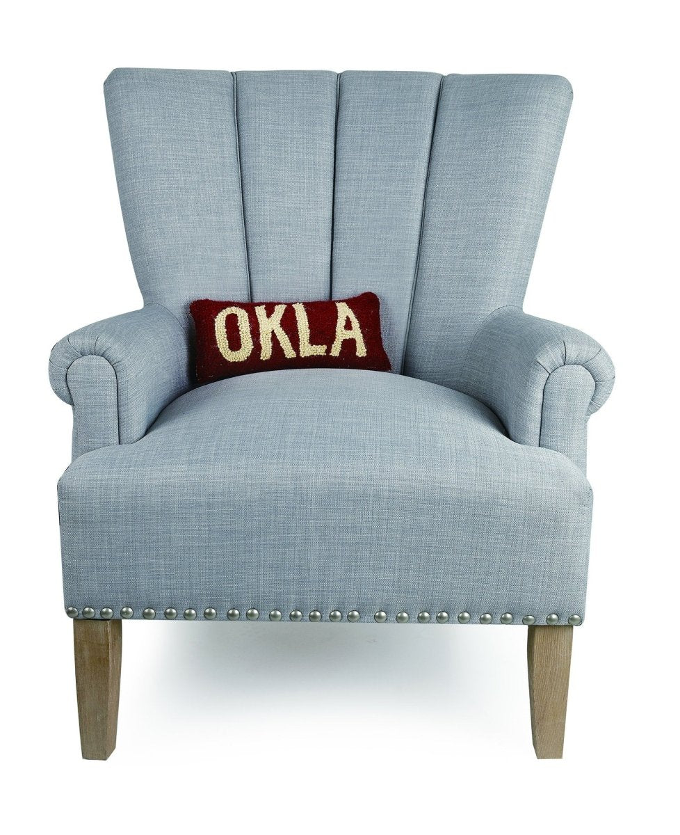 Oklahoma Red/White Hooked Wool Throw Pillow on an armchair, showing the throw pillow at room scale, 12x5 inch