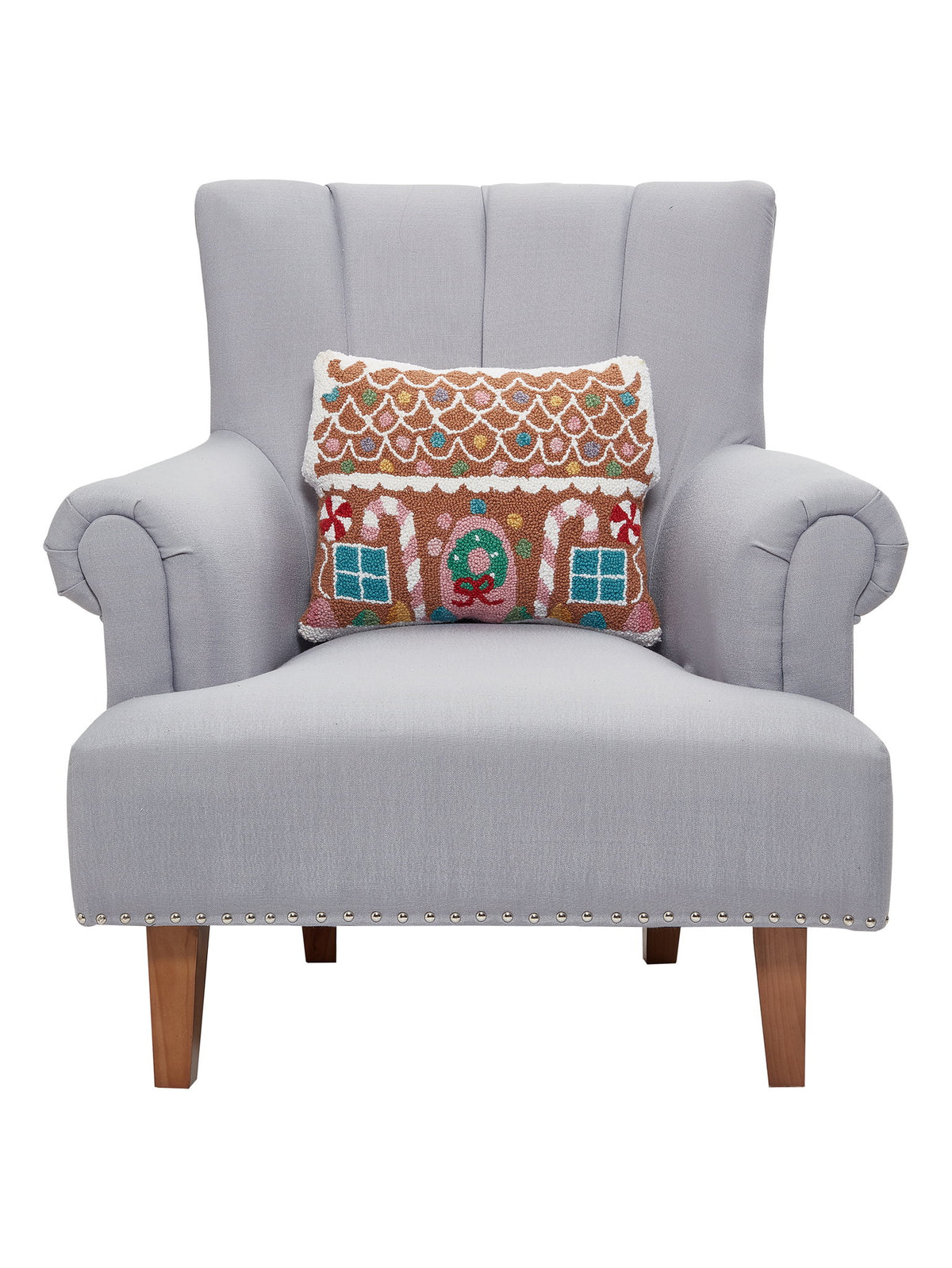 Pastel Gingerbread House Hooked Wool Christmas Throw Pillow on an armchair, showing the throw pillow at room scale, 14x18 inch