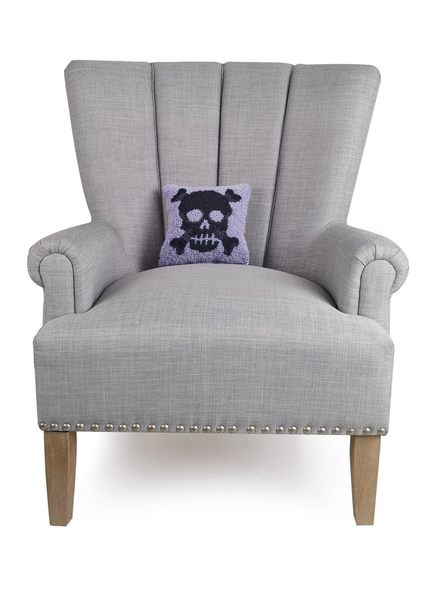Pastel Skull Hooked Wool Halloween Throw Pillow on an armchair, showing the throw pillow at room scale, 8x8 inch