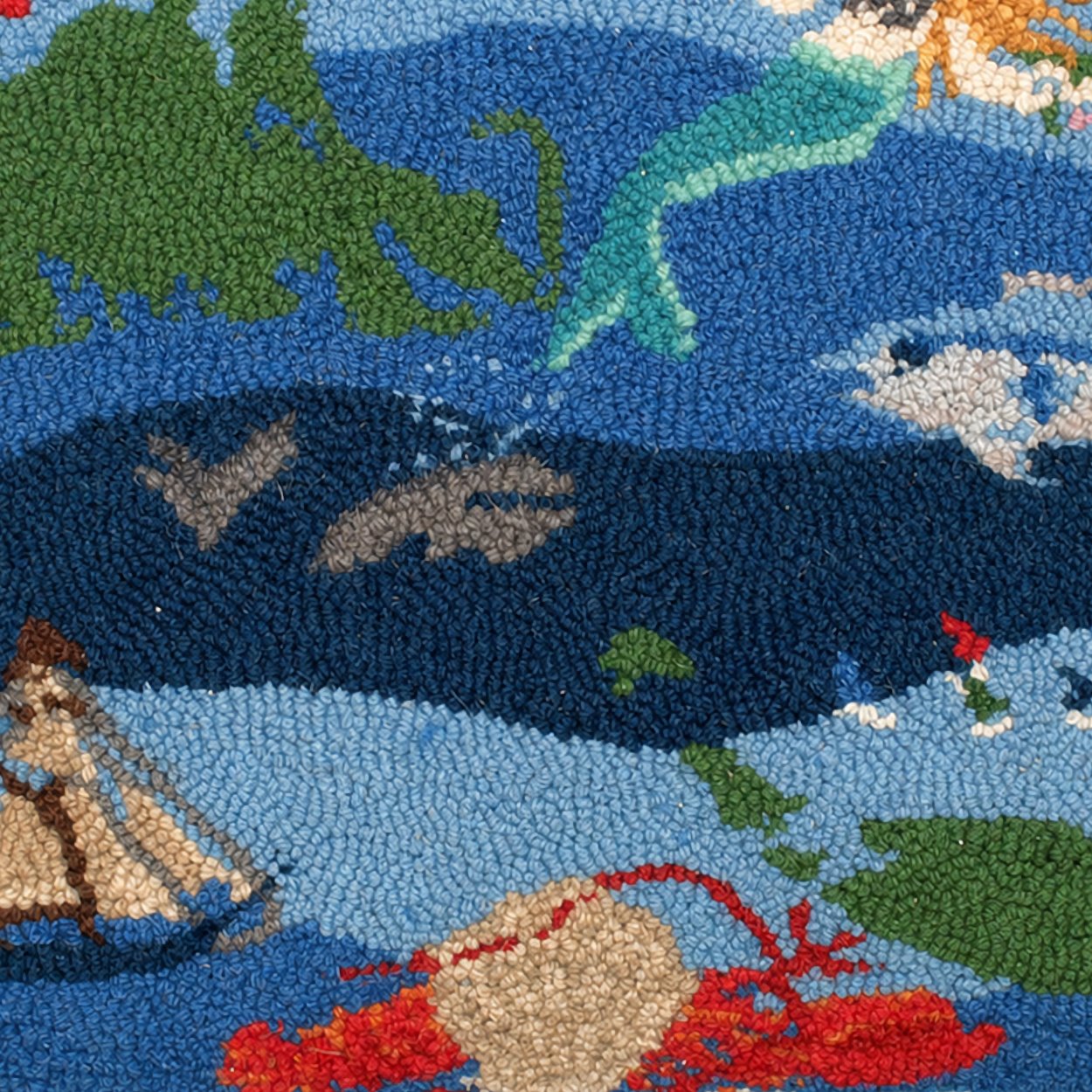 Close-up detail of the Patchwork Ocean hooked pillow showing dimensional wool loops