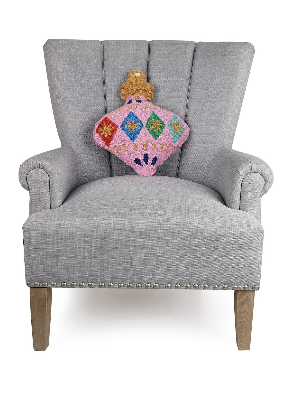 Pink Shaped Hooked Wool Christmas Throw Pillow on an armchair, showing the throw pillow at room scale, 14x18 inch