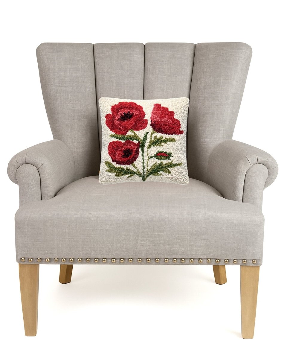 Poppies Hooked Wool Throw Pillow on an armchair, showing the throw pillow at room scale, 10x10 inch