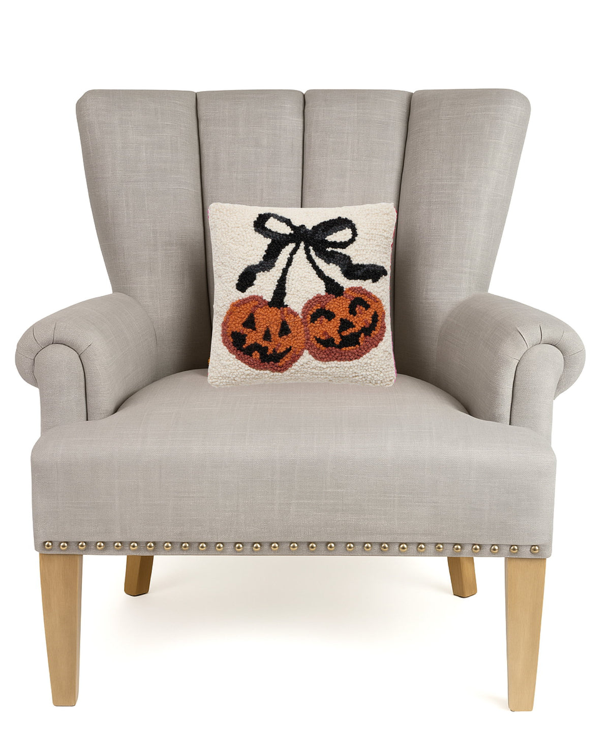 Pumpkin Cherries Hooked Wool Fall Harvest Throw Pillow on an armchair, showing the throw pillow at room scale, 10x10 inch