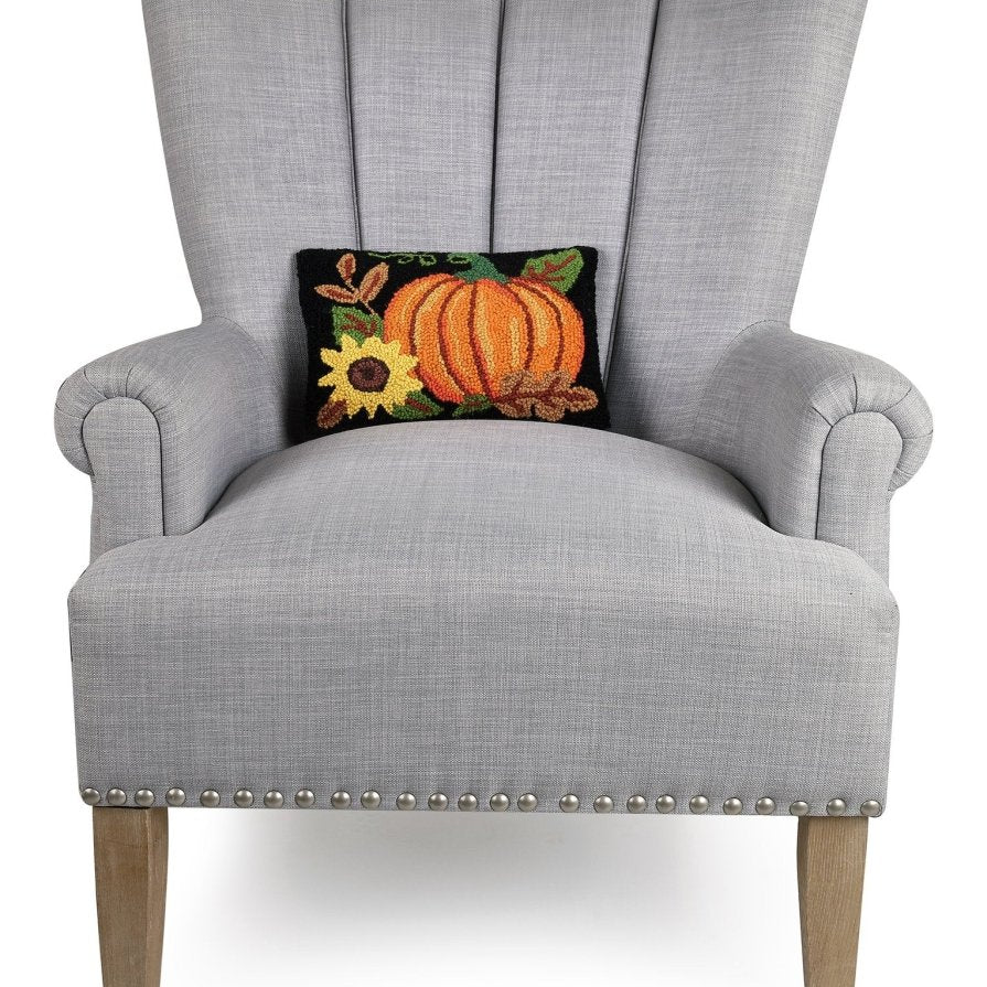 Pumpkin Sunflower Hooked Wool Fall Harvest Throw Pillow on an armchair, showing the throw pillow at room scale, 8x12 inch
