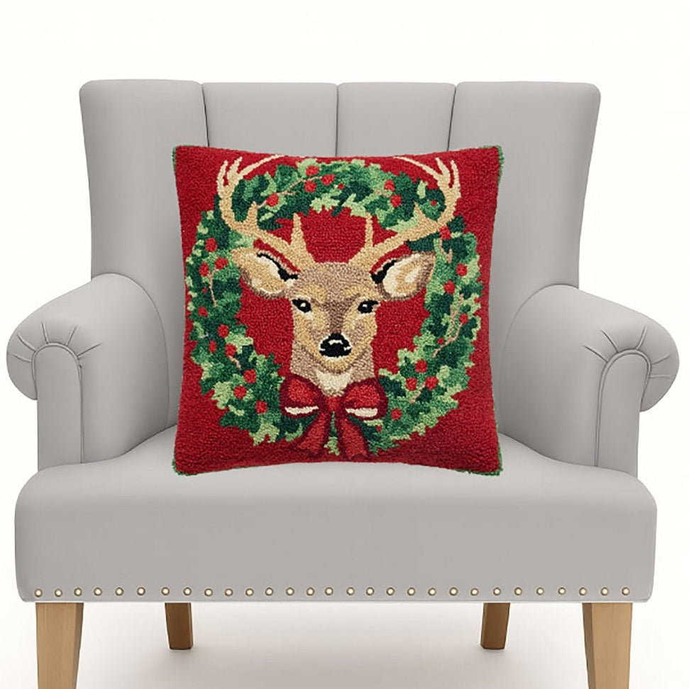 Reindeer Wreath Hooked Wool Christmas Throw Pillow on an armchair, showing the throw pillow at room scale, 18x18 inch