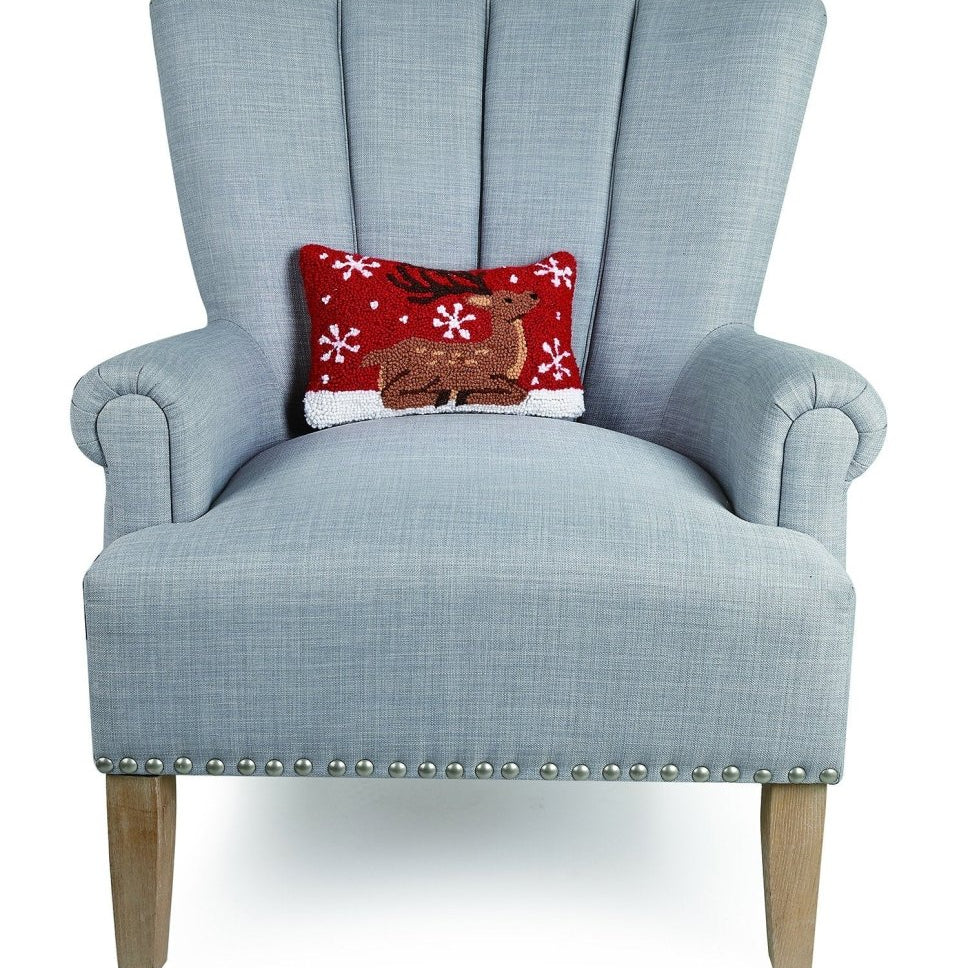 Sitting Reindeer Hooked Wool Christmas Throw Pillow on an armchair, showing the throw pillow at room scale, 8x12 inch