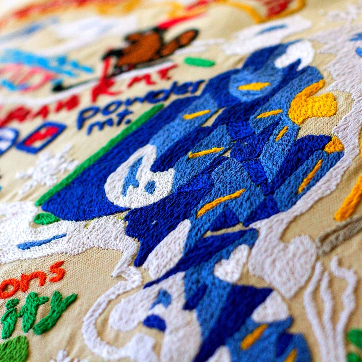 Utah Wasatch Range Embroidered Ski Lodge Pillow - close-up detail of hand-embroidered needlepoint stitching