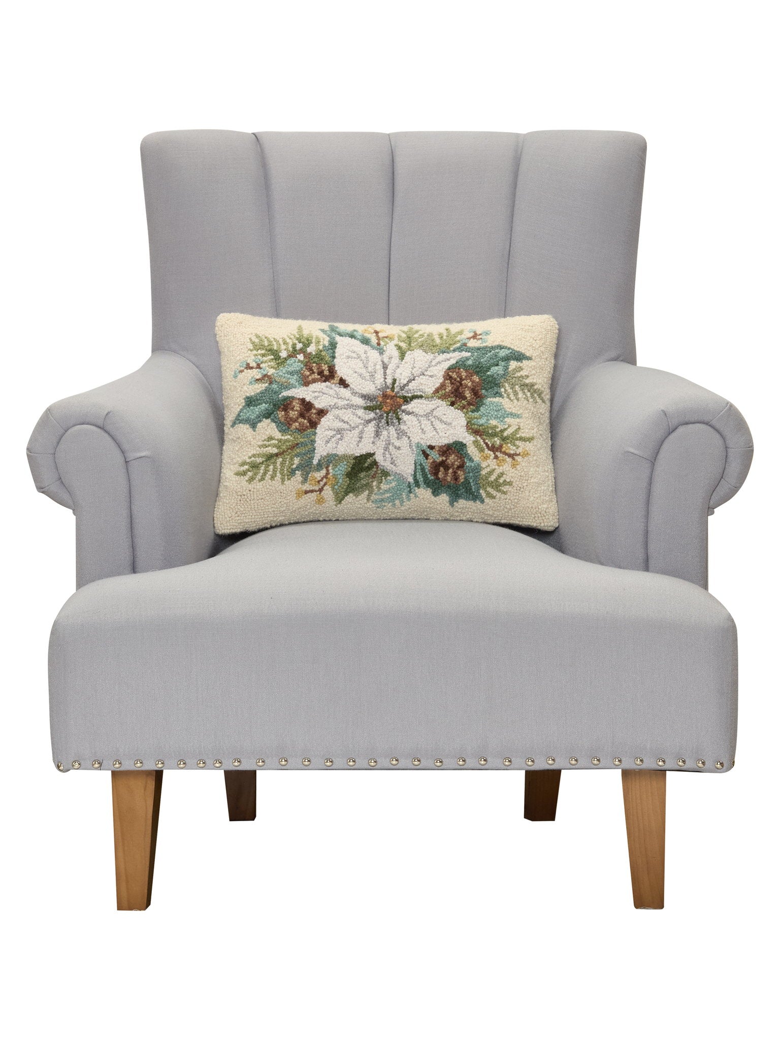 White Poinsettia with Pinecones Hooked Wool Christmas Throw Pillow on an armchair, showing the throw pillow at room scale, 12x18 inch