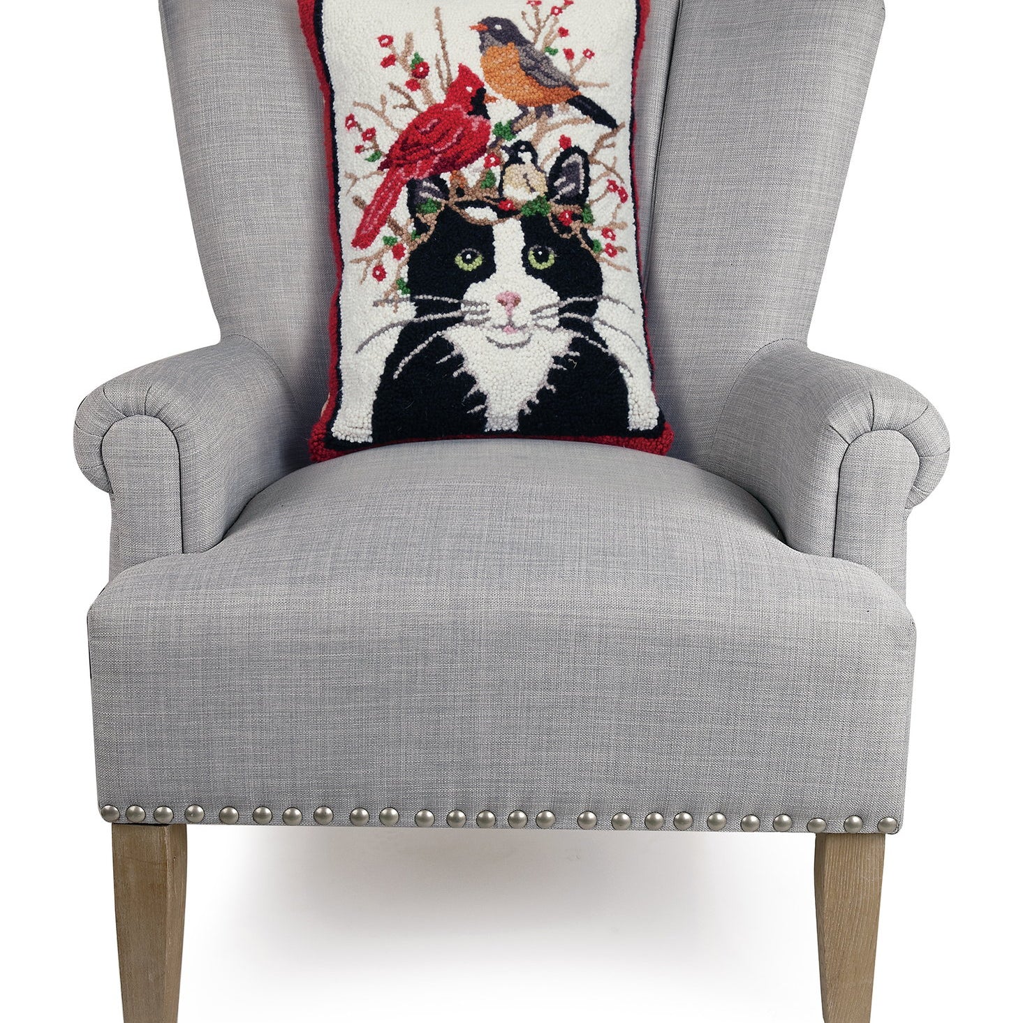 Winter Cat and Birds Hooked Wool Throw Pillow on an armchair, showing the throw pillow at room scale, 14x20 inch