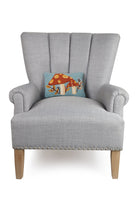 Autumn Mushroom with Leaves Hooked Wool Fall Harvest Throw Pillow on an armchair, showing the throw pillow at room scale, 8x12 inch