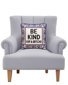Be Kind (of a Bitch) Embroidered Needlepoint Throw Pillow on an armchair, showing the throw pillow at room scale, 12x12 inch