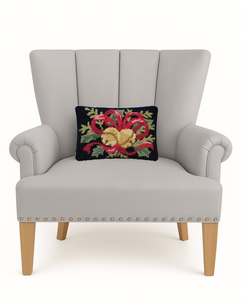 Bells & Ribbon with Foliage Hooked Wool Christmas Throw Pillow on an armchair, showing the throw pillow at room scale, 8x12 inch