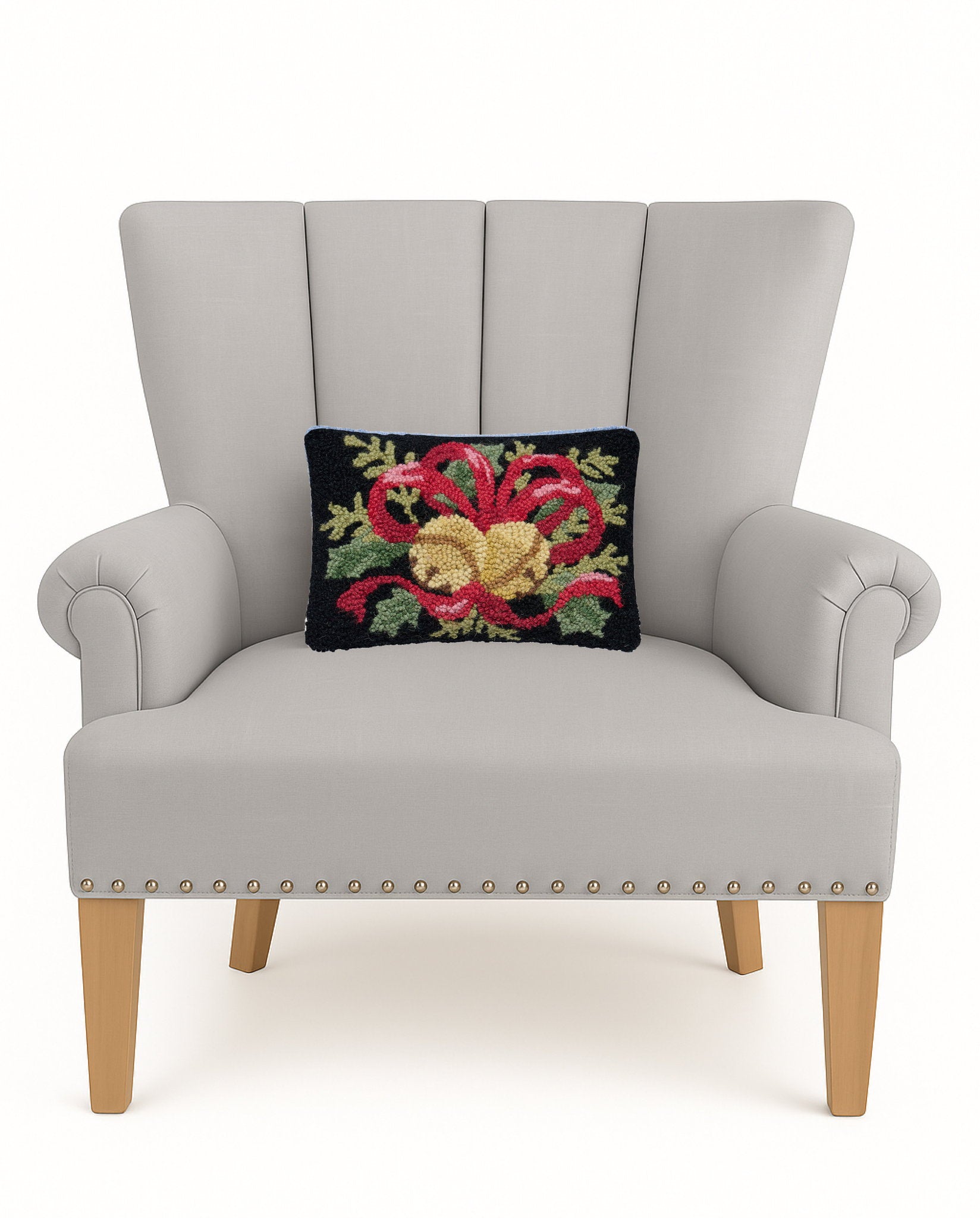 Bells & Ribbon with Foliage Hooked Wool Christmas Throw Pillow on an armchair, showing the throw pillow at room scale, 8x12 inch