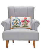 Blue and Magenta Mughal Flower Hooked Wool Throw Pillow on an armchair, showing the throw pillow at room scale, 12x20 inch