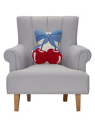 Blue Bow Shaped Cherries Hooked Wool Throw Pillow on an armchair, showing the throw pillow at room scale, 14x16 inch