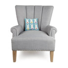 Bunny Backs Hooked Wool Easter Throw Pillow on an armchair, showing the throw pillow at room scale, 10x10 inch