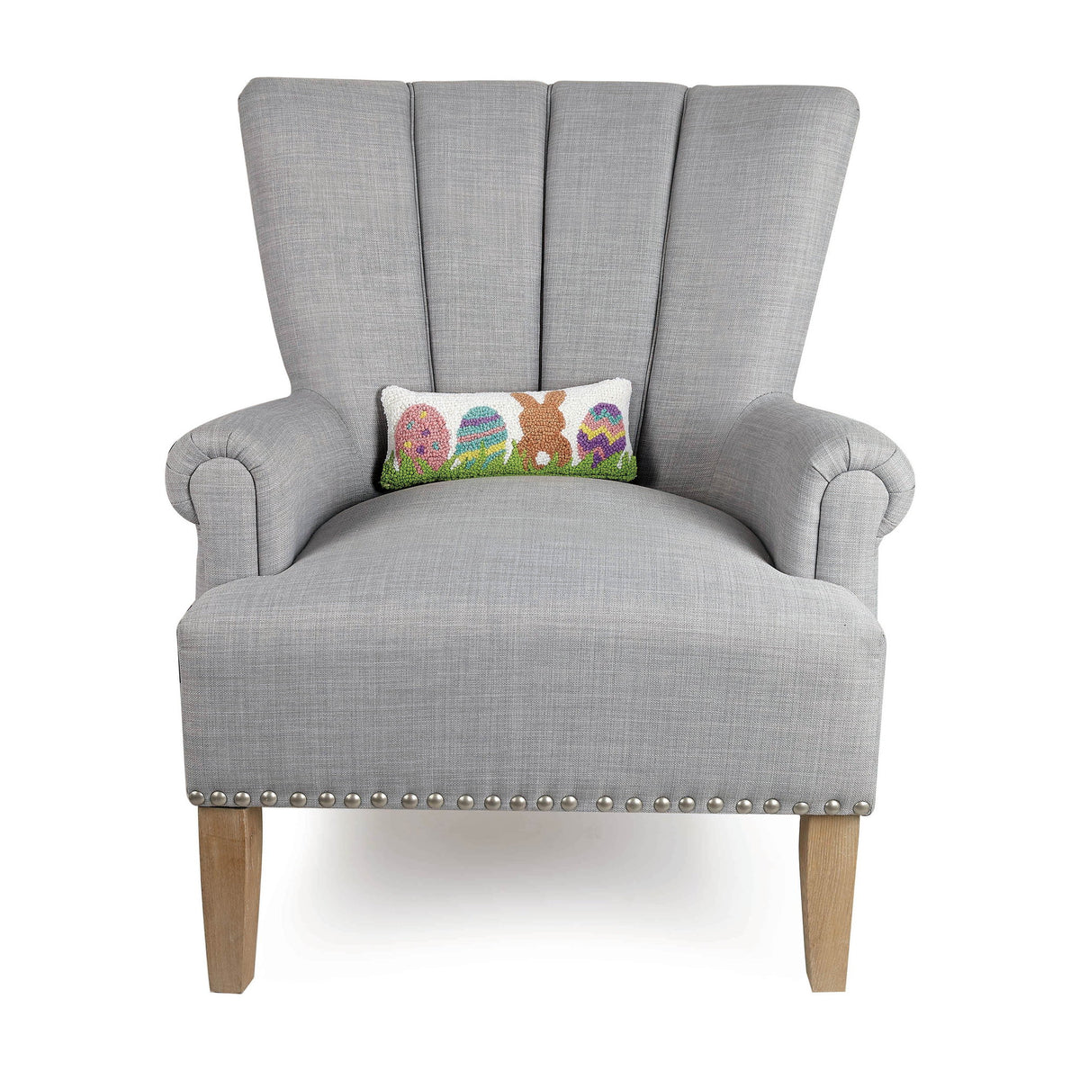 Bunny with Eggs Hooked Wool Easter Throw Pillow on an armchair, showing the throw pillow at room scale, 12x5 inch