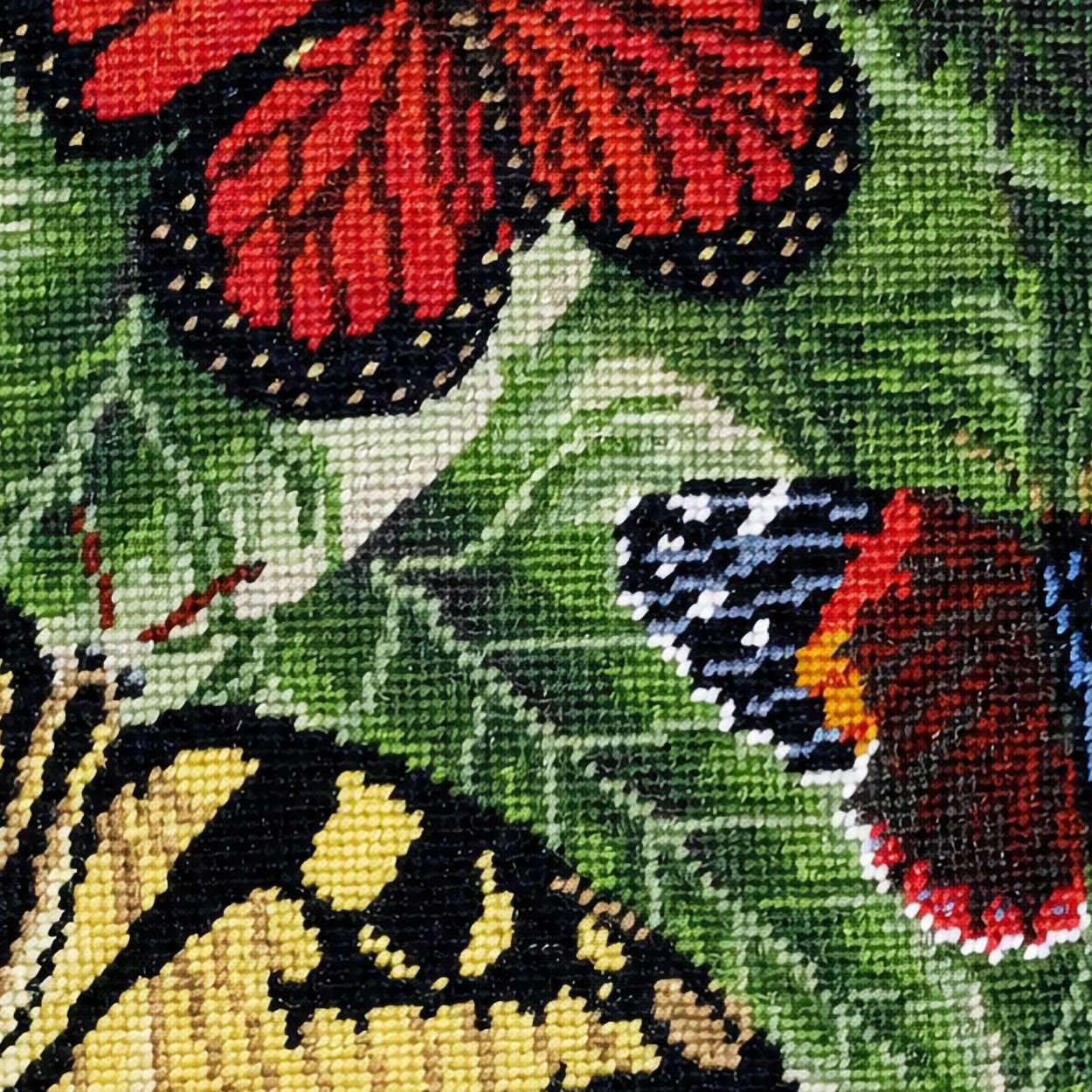 Close-up stitch detail of the Butterflies Colonial Williamsburg needlepoint pillow showing wool texture