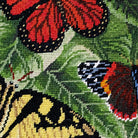 Close-up stitch detail of the Butterflies Colonial Williamsburg needlepoint pillow showing wool texture