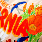 California State Golden Travel Embroidered Throw Pillow - close-up detail of hand-embroidered needlepoint stitching
