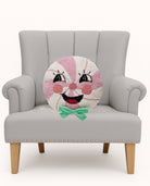 Candy Man with Bow Hooked Wool Christmas Throw Pillow on an armchair, showing the throw pillow at room scale, 16x16 inch