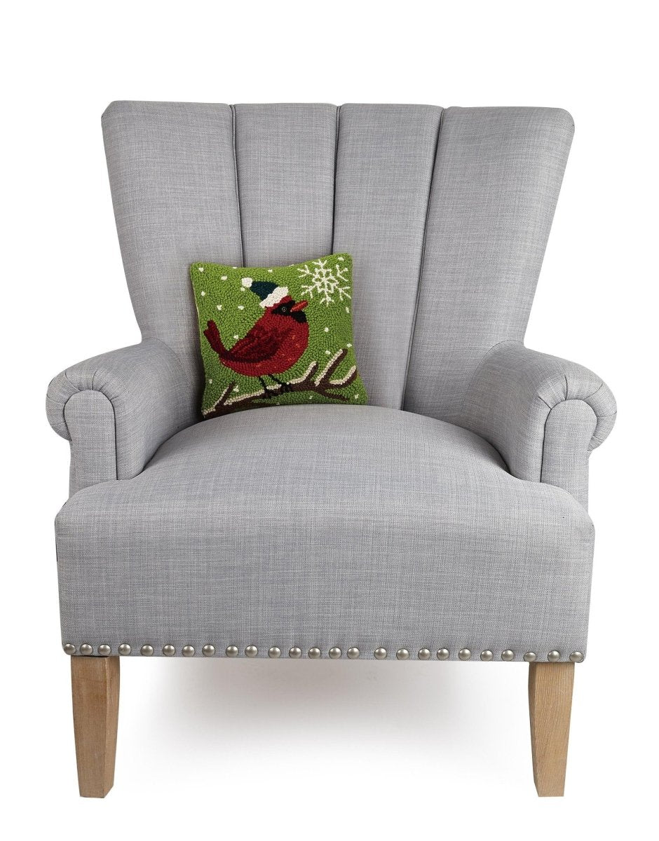 Cardinal with Snowflake Hooked Wool Christmas Throw Pillow on an armchair, showing the throw pillow at room scale, 10x10 inch