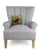 Cardinal with Snowflake Hooked Wool Christmas Throw Pillow on an armchair, showing the throw pillow at room scale, 10x10 inch