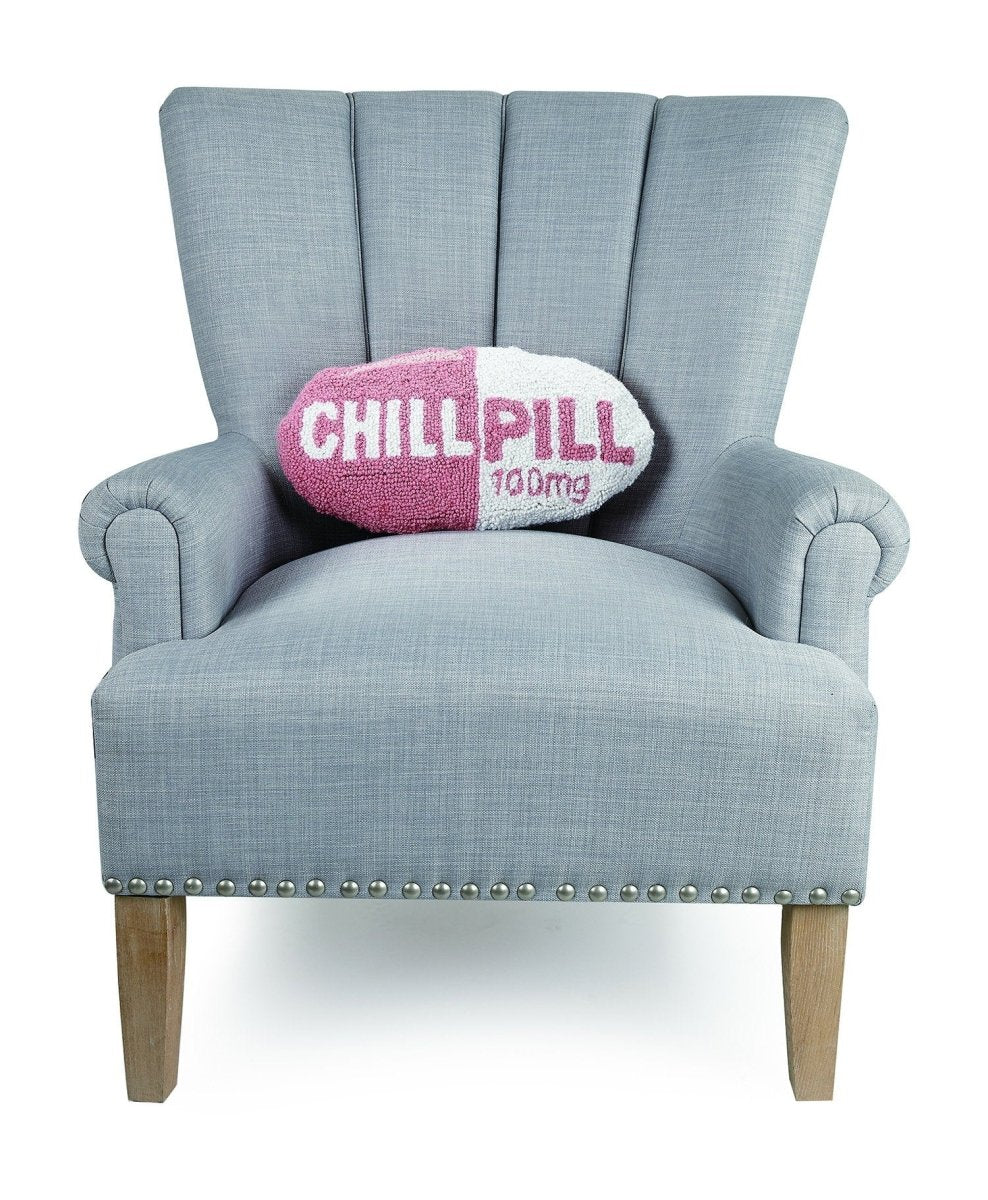Chill Pill Hot Pink Hooked Wool Throw Pillow on an armchair, showing the throw pillow at room scale, 9x16 inch