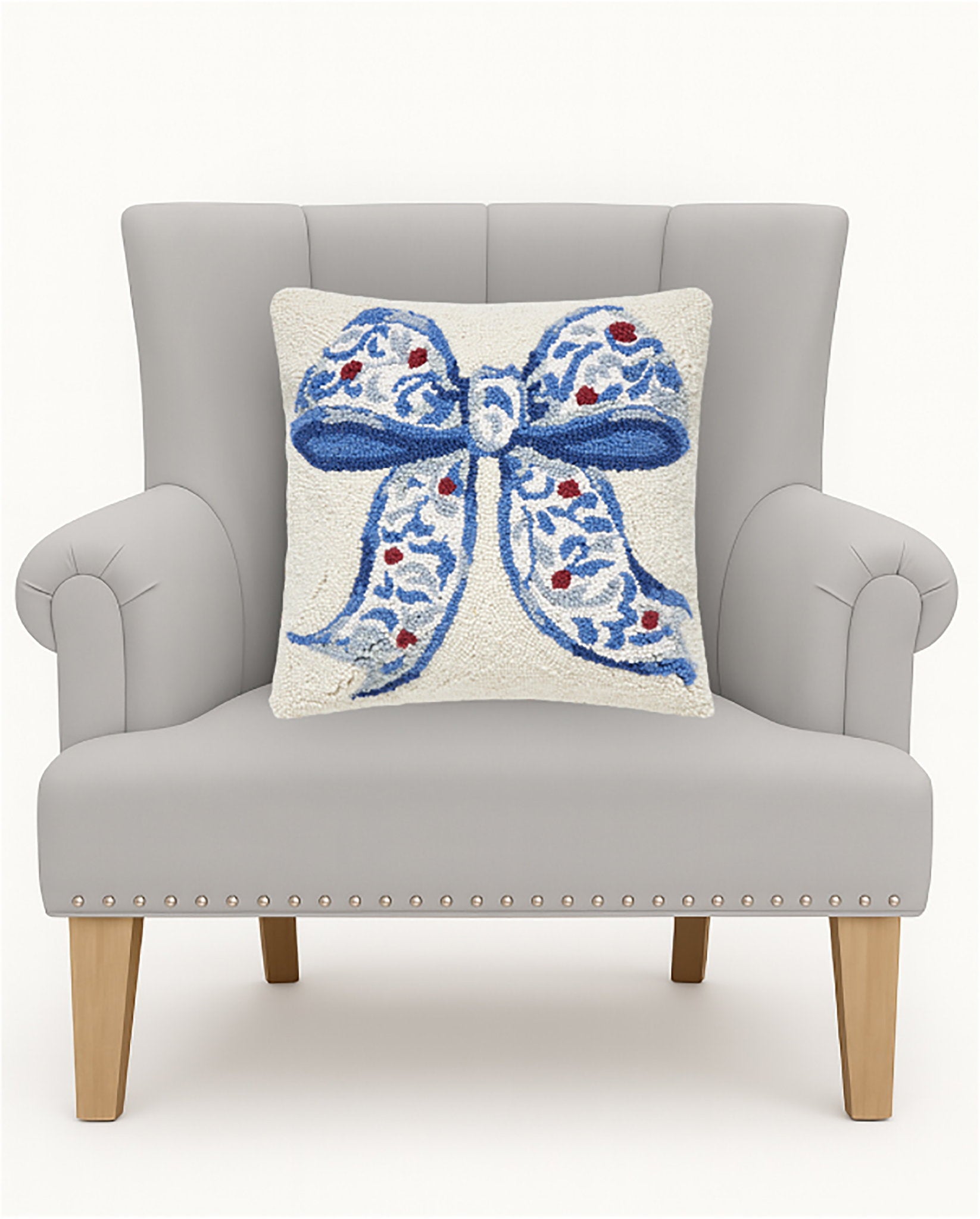 Chinoiserie Bow Hooked Wool Christmas Throw Pillow on an armchair, showing the throw pillow at room scale, 16x16 inch
