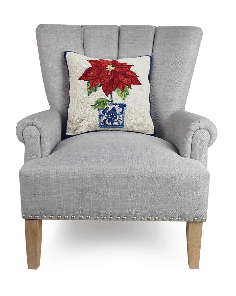 Chinoiserie Poinsettia Hooked Wool Christmas Throw Pillow on an armchair, showing the throw pillow at room scale, 16x16 inch