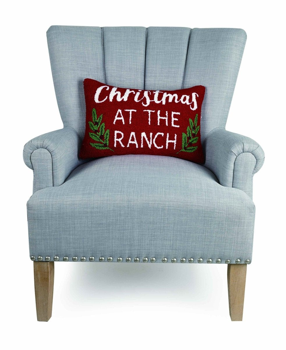 Christmas at the Ranch Hooked Wool Throw Pillow on an armchair, showing the throw pillow at room scale, 12x18 inch