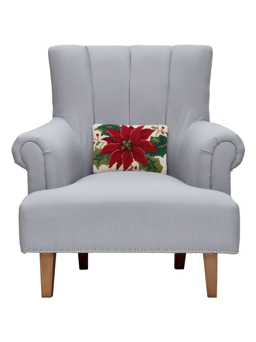 Christmas Poinsettia Hooked Wool Throw Pillow on an armchair, showing the throw pillow at room scale, 8x12 inch